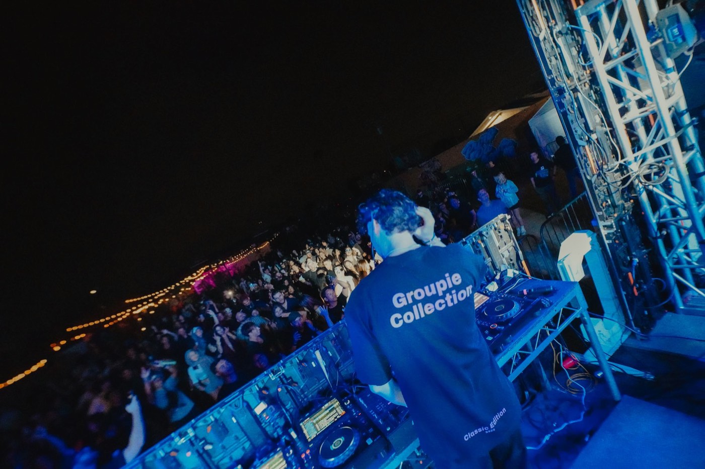 Night stage lit blue over a packed crowd