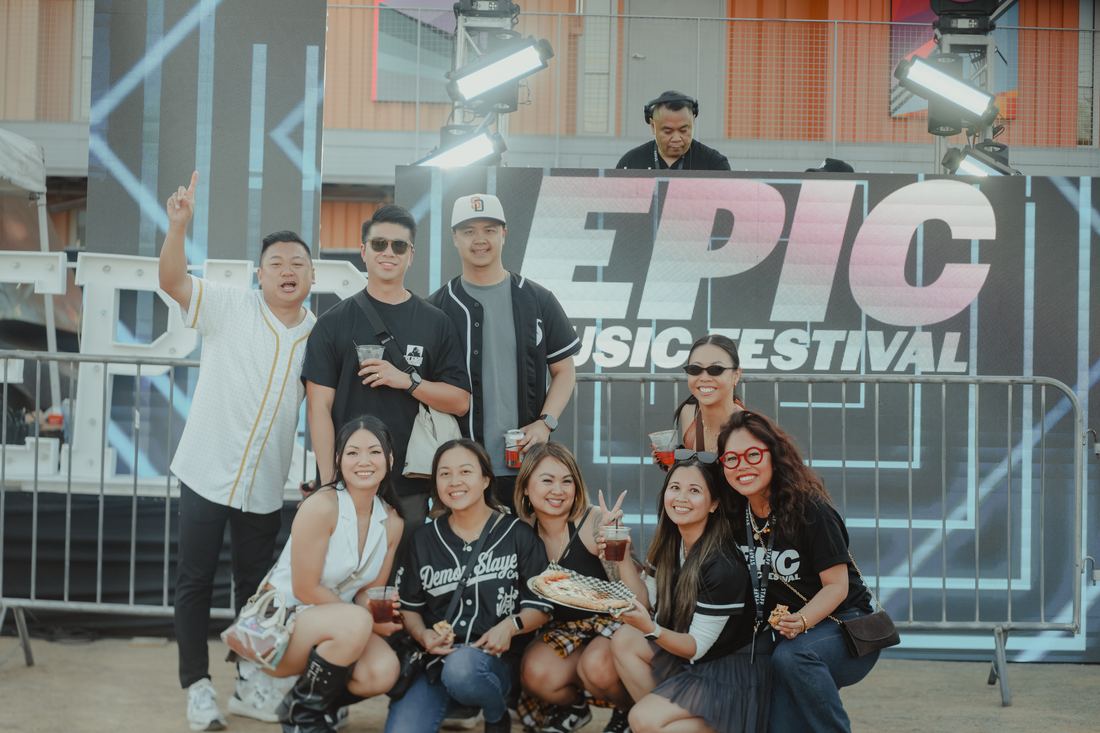Group posing in front of the EPIC Music Festival banner