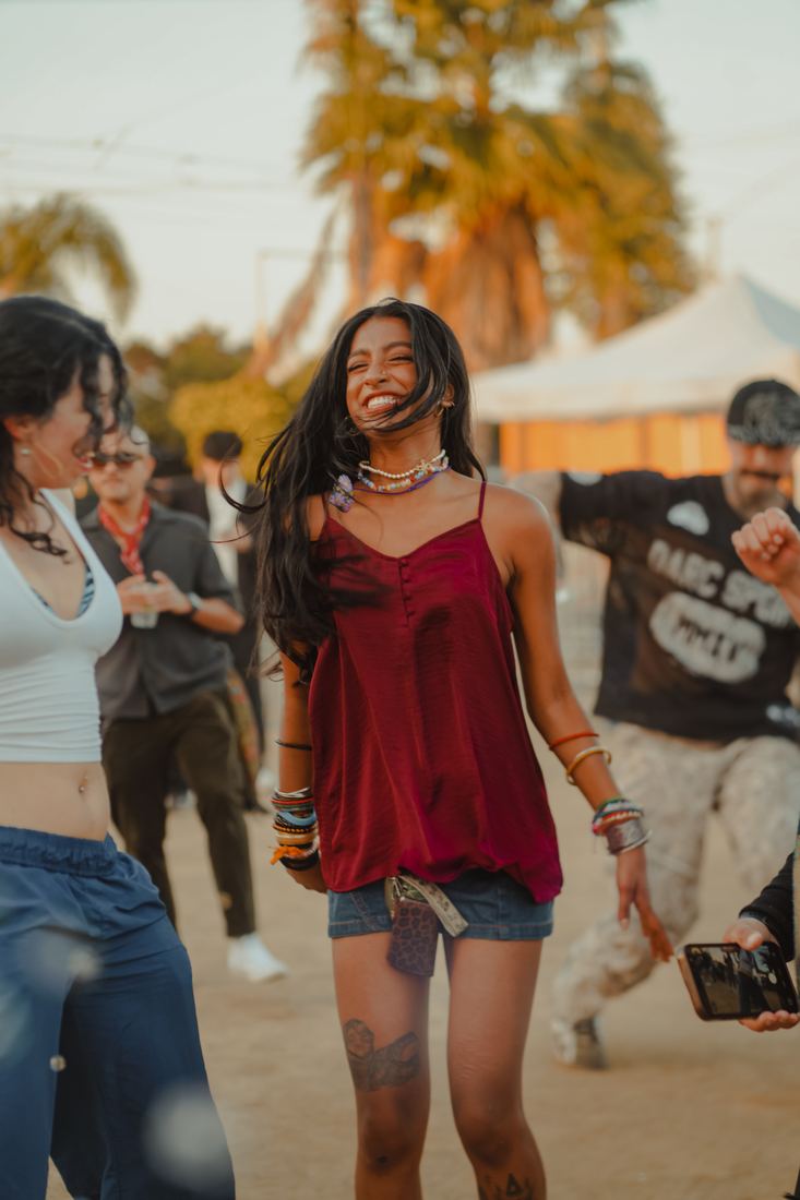Two people walking through the festival in the afternoon sun