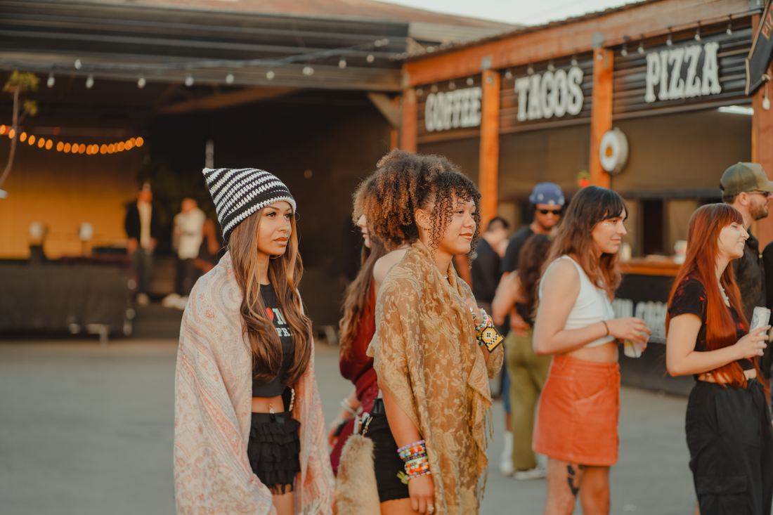 Three people in front of the taco and pizza stand