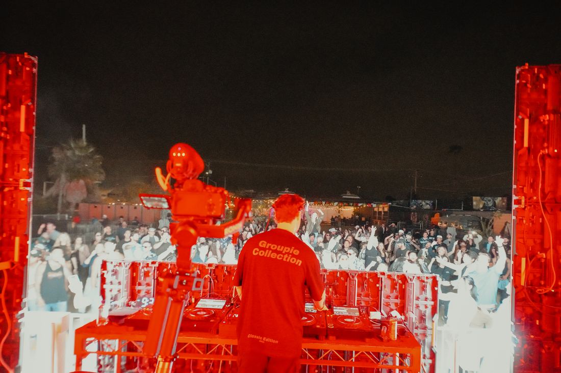 Red lit crowd in front of the stage at night