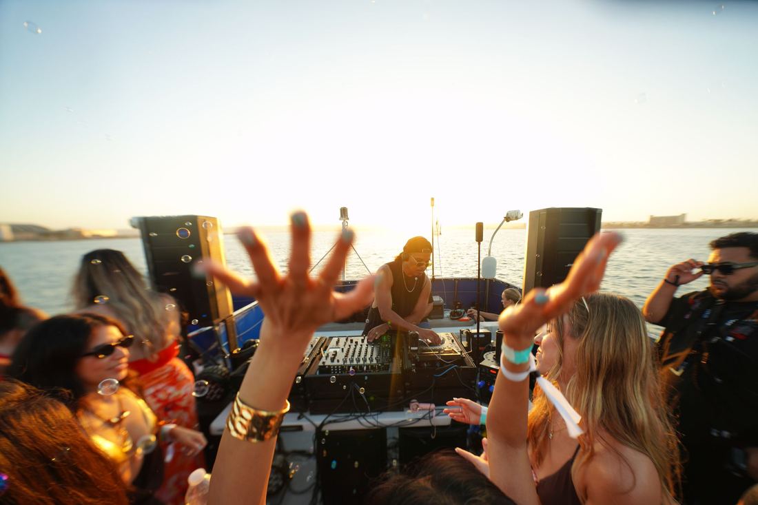 Hands up at sunset on the deck under a pale sky