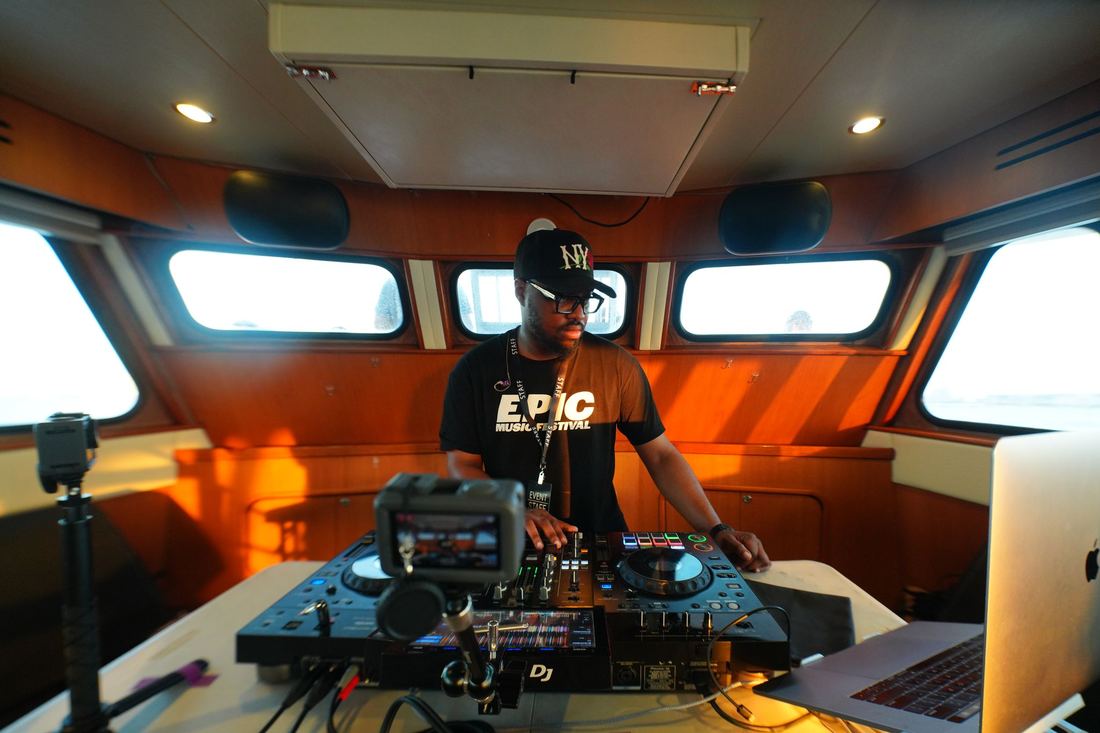 DJ in an EPIC shirt at the decks inside the cabin