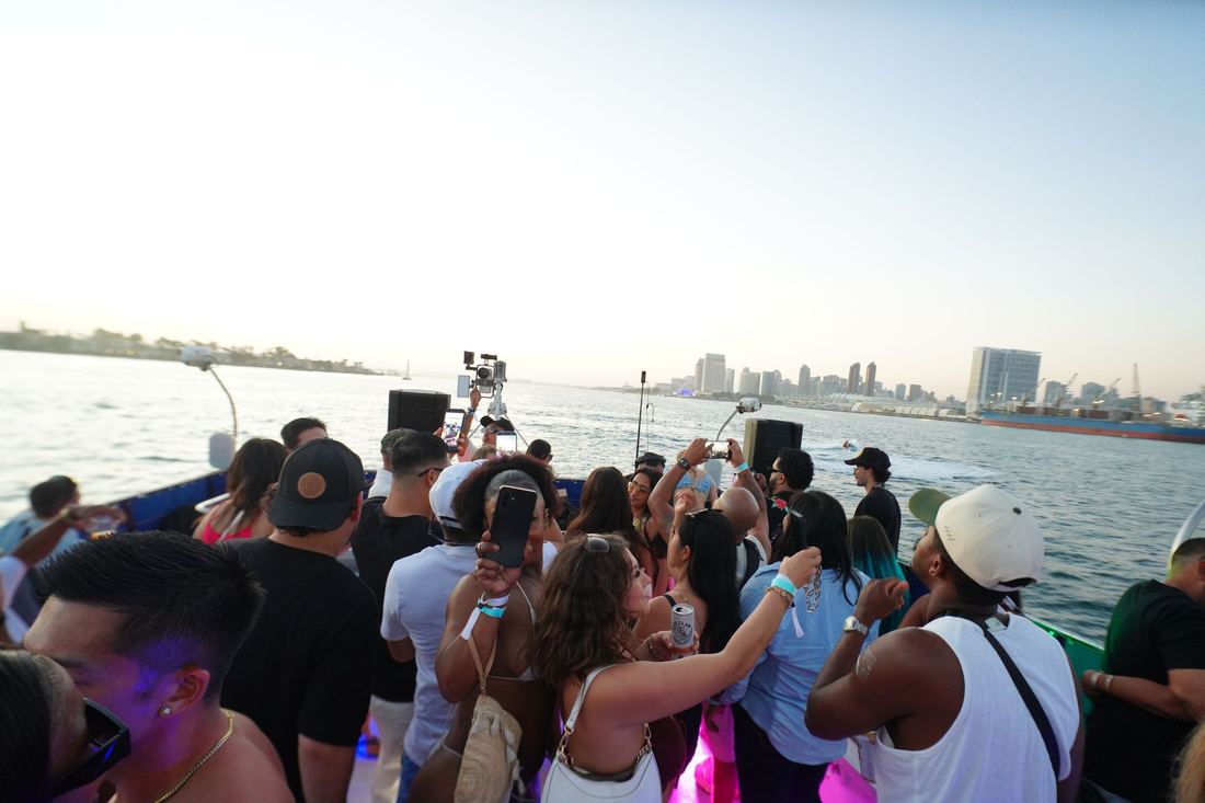 Crowd at the rail with the San Diego skyline behind at dusk