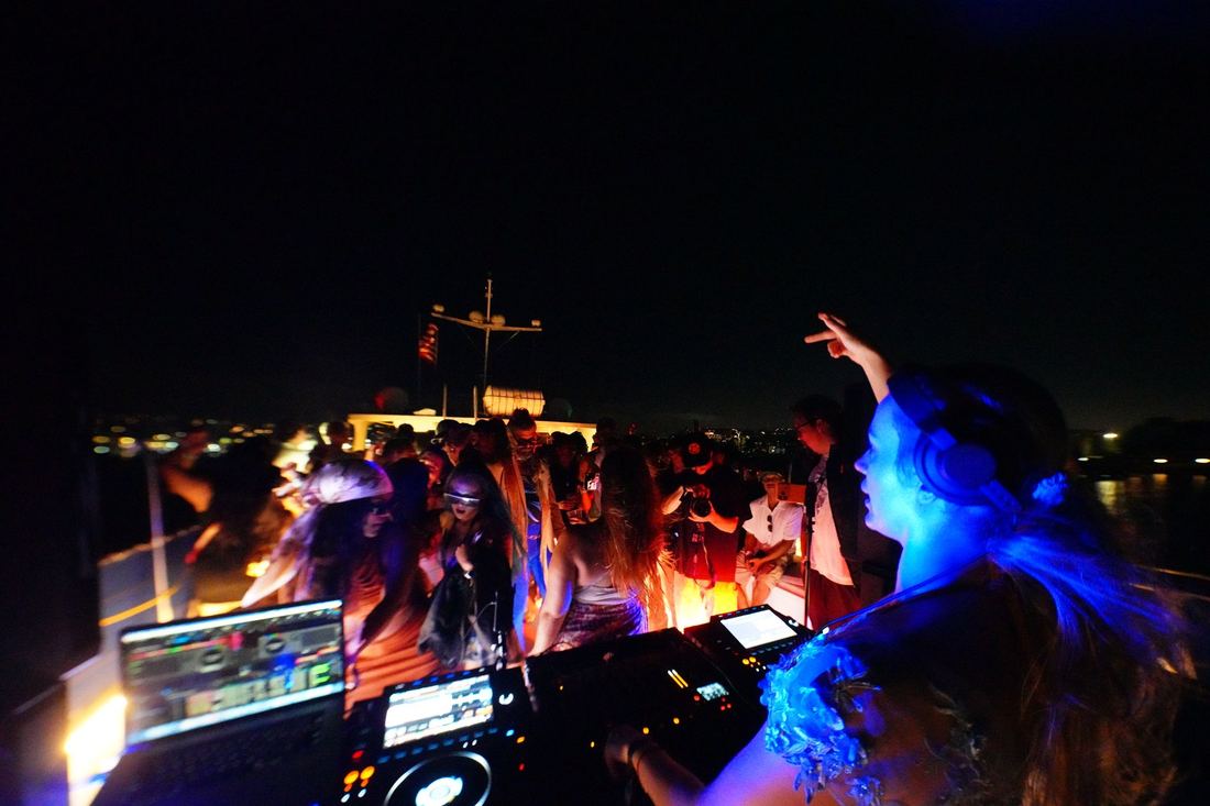 The booth from behind at night, blue light over the crowd