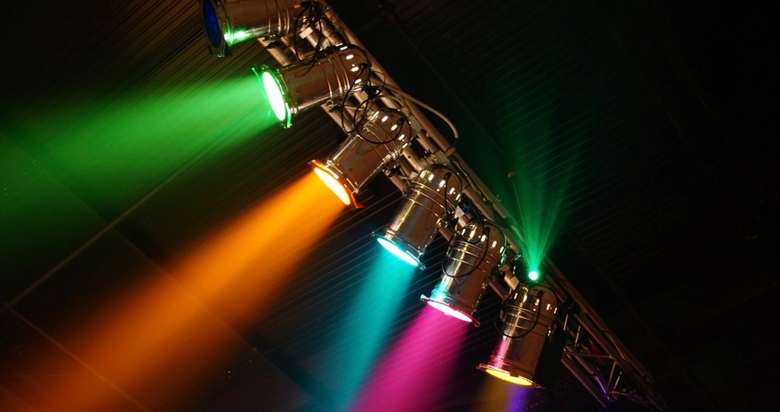 Par cans on a truss throwing green, orange and magenta beams